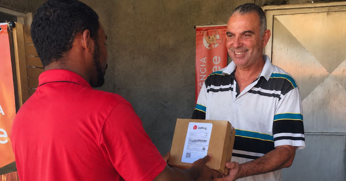 Vendedor entregando caixa com etiqueta da JadLog para postagem do Enjoei no balcão da Vkarlos Log em Sorocaba.